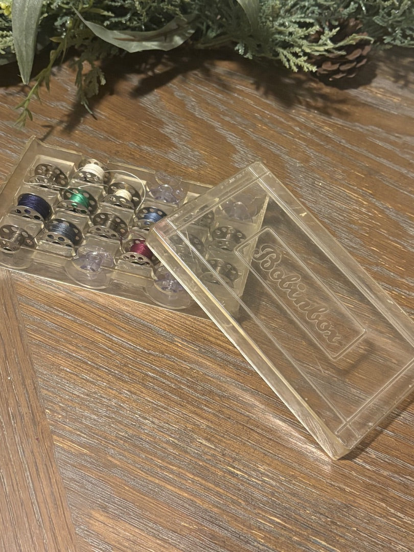 vintage sewing machine bobbins in holder