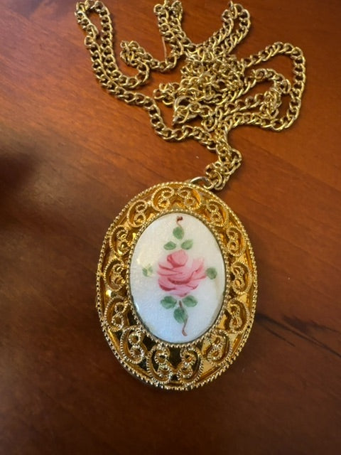 Floral gold tone locket necklace