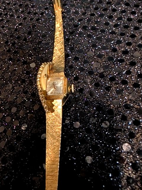 Ladies gold tone "Hidden Face" watch with rhinestones