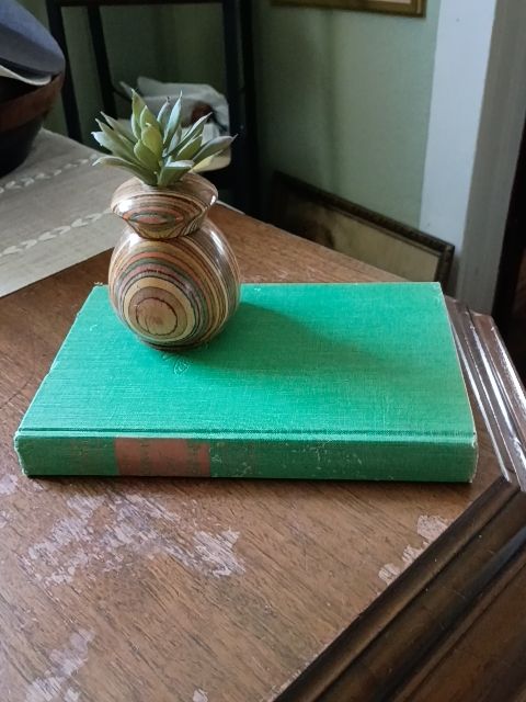Green vintage book display and carved wood planter