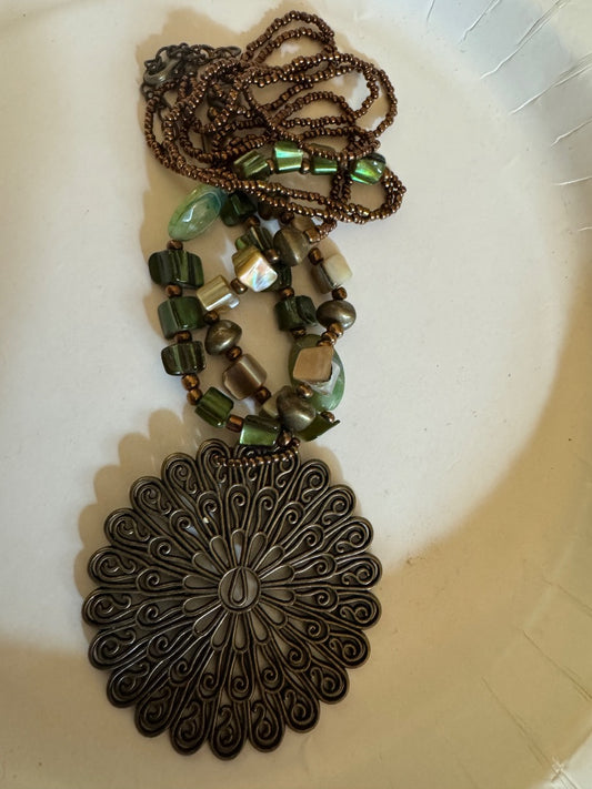Bronze color pendant on seed bead dyed shell necklace