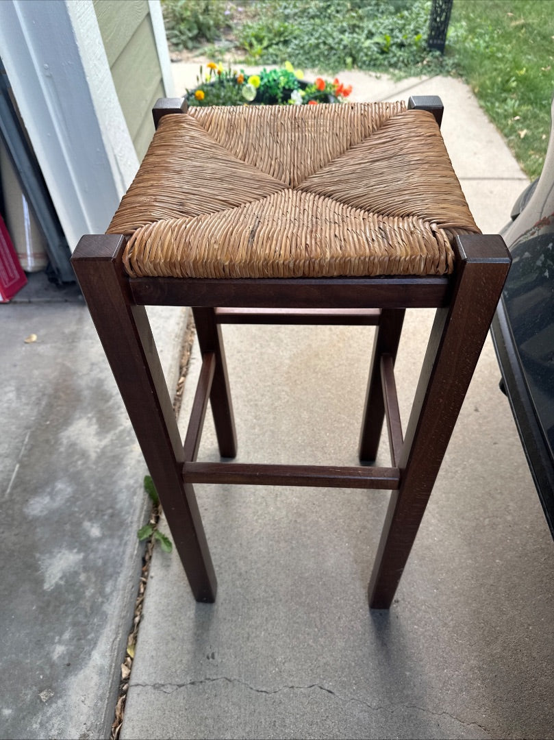 Dark brown, wooden barstool or plant stand with woven top