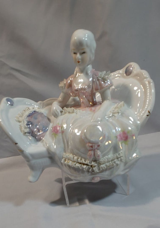 Iridescent with pinks Taiwan Victorian-style porcelain figurine on sofa, 7"