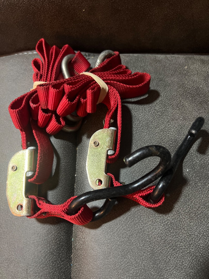 red tie-down straps shown are cam buckle style straps with vinyl-coated S hooks