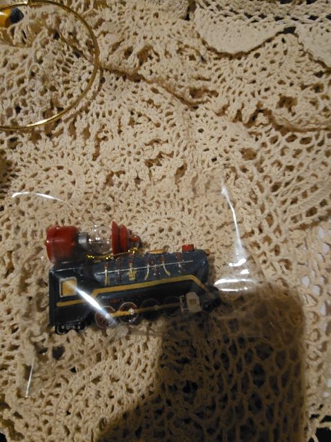 Kurt S. AdlerDesign: Steam locomotive engine in navy blue with red accents, gold lettering, and a clear lantern/light fixture on top